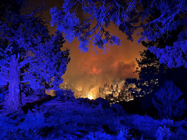 Smoke billows and flames rise as the Flat Fire burns in a location given as Deschutes County, Oregon, U.S., in this handout image released on August 23, 2025. (Photo by Deschutes County Sheriff's Office via Facebook/Handout via Reuters)