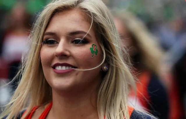 A woman enjoys the party atmosphere during the St Patrick's day parade in Dublin, Ireland, Monday March, 17, 2014. The world's largest parade celebrating Irish heritage set off on a cold and gray morning, the culmination of a weekend of St. Patrick's Day revelry. (Peter Morrison/AP Photo)