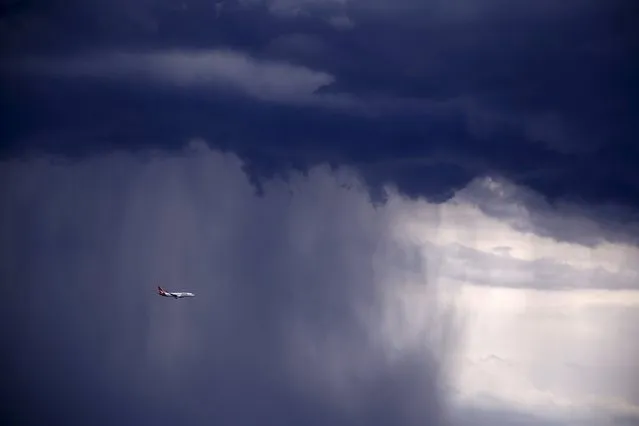 A Qantas Boeing 737-800 plane flies through heavy rain as a storm moves towards the city of Sydney, Australia, November 6, 2015. Powerful storms swept across the city on Friday, with the Australian Bureau of Meteorology issuing a warning for severe thunderstorms with large hailstones, heavy rainfall and damaging winds, local media reported. (Photo by David Gray/Reuters)