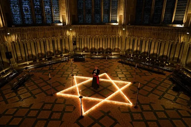 The Reverend Canon Michael Smith, Acting Dean of York, lights some of the 600 candles in the shape of the Star of David on the floor of the Chapter House of York Minster as part of a commemoration for Holocaust Memorial Day on January 26, 2022 in York, England. This year marks the 77th anniversary since the liberation of the Auschwitz-Birkenau concentration camp in 1945, which was the largest Nazi death camp. The Holocaust genocide took place during World War II during which Adolf Hitler's Nazi Germany and its collaborators systematically murdered some six million European Jews. (Photo by Ian Forsyth/Getty Images)