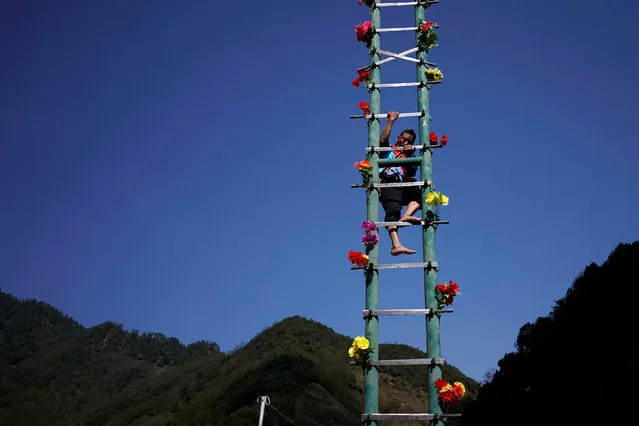 An ethnic Lisu man climbs a knives ladder to celebrate the annual Knife Pole Festival in Luzhang township of Nujiang Lisu Autonomous Prefecture in Yunnan province, China, March 29, 2018. (Photo by Aly Song/Reuters)