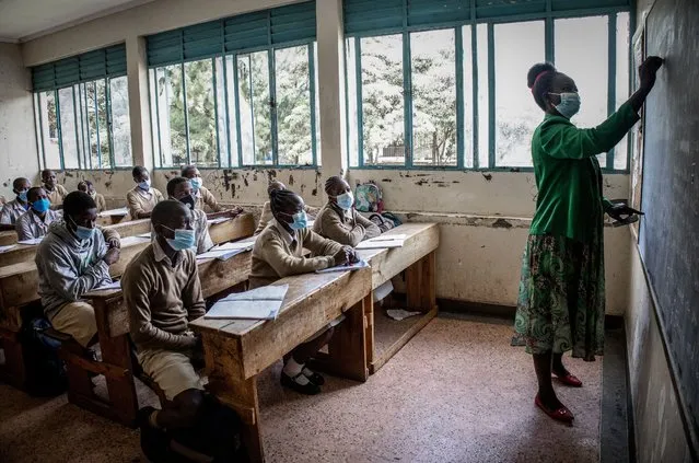 A teacher in class wearing a face mask as a precaution at Ayany Primary School in Nairobi, Kenya on November 17, 2020. After a long period of closure due to the coronavirus pandemic schools reopened under precautionary measures such as social distancing between pupils in classes, having students temperatures checked regularly and washing hands with sanitiser. (Photo by Donwilson Odhiambo/SOPA Images/LightRocket via Getty Images)