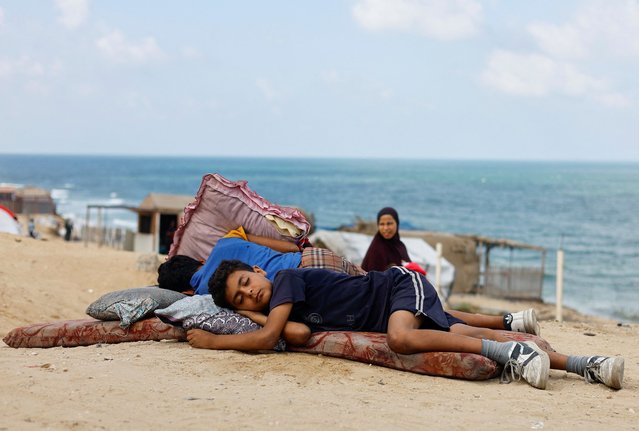 Displaced Palestinian children fleeing northern Gaza due to an Israeli military operation rest as they move southward after Israeli forces ordered residents of Gaza City to evacuate to the south, in the central Gaza Strip, on September 19, 2025. (Photo by Mahmoud Issa/Reuters)