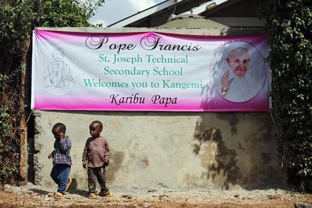 Children walk beneath a banner welcoming Pope Francis in Nairobi's Kangemi neighborhood, where Pope is scheduled to pay a visit, in Nairobi, Kenya, 13 November 2015. Kenya is preparing for the upcoming papal visit in late November, his first stop on a three-nation Africa tour. (Photo by Dai Kurokawa/EPA)