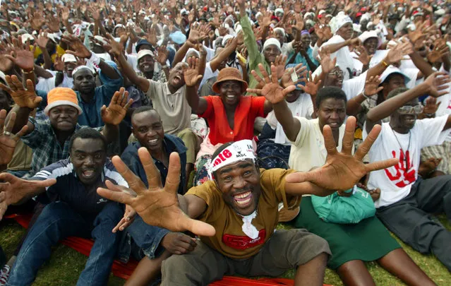 Zimbabwe opposition Movement for democrtic Change supporters cheering at an election rally in Mabutweni township. Zimbabwe opposition Movement for Democratic Change (MDC) supporters cheer at an election rally in Mabutweni township near Bulawayo at the White City stadium, March 26, 2005. (Photo by Juda Ngwenya/Reuters)