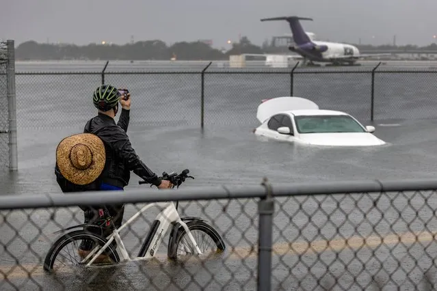 A person takes pictures of a car that is stranded in flood water on Fort Lauderdale International Airport's West Perimeter road in Fort Lauderdale, Florida, USA, 13 April 2023. Heavy rains in the past days produced flooding in the lower areas of the Miami-Dade and Broward counties. (Photo by Cristobal Herrera-Ulashkevich/EPA/EFE/Rex Features/Shutterstock)