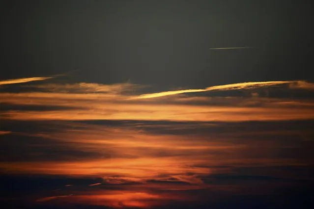 An aeroplane flies over Graveney and the Kent countryside as the sun sets over on a clear autumn evening Britain October 26, 2015. (Photo by Dylan Martinez/Reuters)