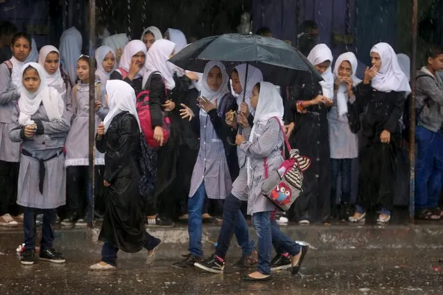 Palestinian schoolgirls hold an umbrella as they go to school on a rainy day in Khan Younis in the southern Gaza Strip October 7, 2015. (Photo by Ibraheem Abu Mustafa/Reuters)