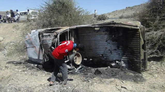 A boy looks at the wreckage of a car hit by an air strike in the central Yemeni province of al-Bayda April 19, 2014. (Photo by Reuters/Stringer)