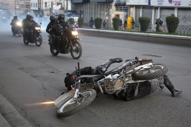 Riot police officers fall off a motorcycle during clashes between supporters of Bolivian President Luis Arce and pro-government leader Evo Morales in La Paz, Bolivia, 23 September 2024. Supporters of former Bolivian President Evo Morales asked the electoral body to recognize the congress in which they defined the candidacy of the former president in the 2025 elections, threatening with national road blockade upon denial. On 23 September, Morales gave an ultimatum to President Luis Arce, demanding to change his ministers within 24 hours if he wanted to finish his term in office. (Photo by Luis Gandarillas/EPA/EFE)
