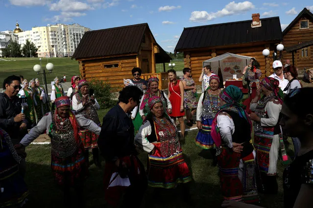 Tourists dance with folk performers at a Mordovian culture exhibition at a square in downtown of Saransk, Russia June 17, 2018. (Photo by Ricardo Moraes/Reuters)