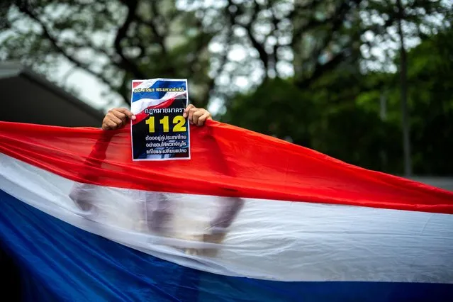A pro-royalist activist holds a banner supporting Article 112, lese-majeste law, during a rally calling the U.S. not to interfere in Thailand's election process, in front of the U.S. embassy in Bangkok, Thailand on May 24, 2023. (Photo by Athit Perawongmetha/Reuters)