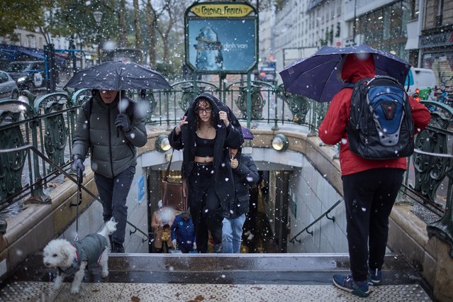 A commuter exits Colonel Fabien Metro station in heavy snowfall as Paris is placed under the second highest weather warning by the French national weather service for snow, in central Paris on November 21, 2024. Snow all the way to the plains, temperatures worthy of January: the first flakes of storm Caetano fell in France on November 21, where 54 departments are on “orange alert” for snow, ice and wind. (Photo by Kiran Ridley/AFP Photo)