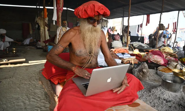 A Sadhu works on an Apple laptop at Sangam on the occasion of Basant Panchami Festival during the ongoing Magh Mela Festival in Prayagraj on February 16, 2021. (Photo by Prabhat Kumar Verma/ZUMA Wire/Rex Features/Shutterstock)