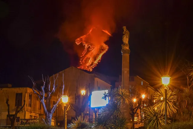 This photo taken late on February 21, 2021 in Milo, near Catania, Sicily, and obtained on February 22, 2021 from Italian news agency Ansa, shows lava flowing along the sides of the southern crater of the Etna volcano as a new eruptive episode of tall lava fountains, known as paroxysm, occurred. (Photo by ANSA/Handout via AFP Photo)