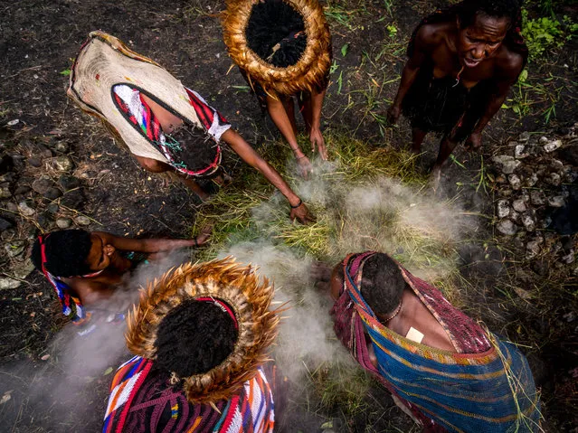 Dani tribeswomen usen traditional oven to cook food in, Western New Guinea, Indonesia, August 2016. (Photo by Teh Han Lin/Barcroft Images)