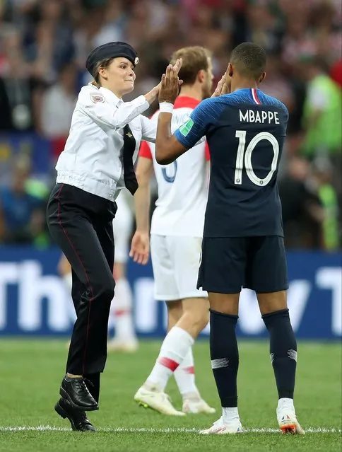 A pitch invader high fives Kylian Mbappe of France during the 2018 FIFA World Cup Final between France and Croatia at Luzhniki Stadium on July 15, 2018 in Moscow, Russia. (Photo by Clive Rose/Getty Images)