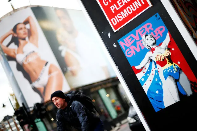 A caricature of Hillary Clinton as Wonder Woman with her message to young girls from her speech after conceding the U.S. elections is seen in front of a giant advertisement for designer underwear in east London, Britain November 18, 2016. (Photo by Andrew Winning/Reuters)
