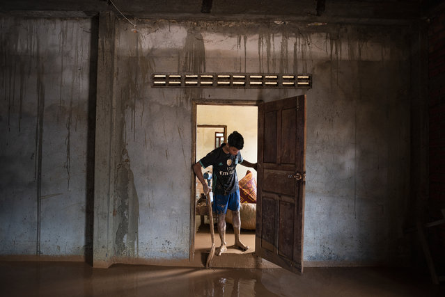 Villagers cleanup their properties after mud and flash floods engulfed their villages the other day, on July 26, 2018 in Attepeu, southern Laos. At least 26 people were killed and over 3,000 people stranded after a hydroelectric dam built collapsed in southeastern Laos, destroying thousands of homes and leaving an unknown number of dead. According to state media, 5 billion cubic metres of water swept away houses across 7 villages and made more than 6,600 people homeless after the accident at the Xepian-Xe Nam Noy hydropower dam as rescuers are racing to find survivors and top government officials rushed to the site. (Photo by Jes Aznar/Getty Images)