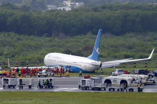 A Boeing passenger plane from China, a Xiamen Air, sits on the grassy portion of the runway of the Ninoy Aquino International Airport after it skidded off the runway while landing Friday, August 17, 2018 in suburban Pasay city southeast of Manila, Philippines. All the passengers and crew of Xiamen Air Flight 8667 were safe and were taken to an airport terminal, where they were given blankets and food before being taken to a hotel. (Photo by Bullit Marquez/AP Photo)
