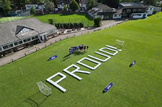 In an aerial view, white letters “PROUD!” are spelled out in footballs on the green grass in the flight path of Heathrow Airport as the National Lottery funded club Actonians Ladies FC welcomes the Lionesses home with pride on August 21, 2023 in London, England. (Photo by Jim Meehan/Getty Images The National Lottery)
