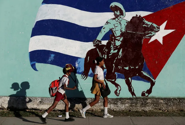 Cuban students walk in front of a mural of the Cuban flag in Havana, Cuba, November 22, 2016. (Photo by Enrique de la Osa/Reuters)