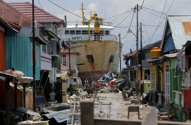 In this Tuesday, October 2, 2018, file photo, a ship rests near houses after it was swept ashore during Friday's tsunami at a neighborhood in Donggala, Central Sulawesi, Indonesia. Five days after Indonesia’s earthquake and tsunami devastated villages on Sulawesi island, residents hoping that help would soon arrive are angry because it hasn’t. (Photo by Tatan Syuflana/AP Photo)