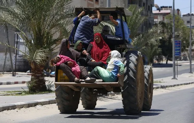 Palestinian family sit in a truck as they fleeing their house in Gaza City, Tuesday, May 18, 2021. Since the fighting began last week, the Israeli military has launched hundreds of airstrikes it says are targeting Hamas' militant infrastructure, while Palestinian militants have fired thousands of rockets into Israel. (Photo by Hatem Moussa/AP Photo)