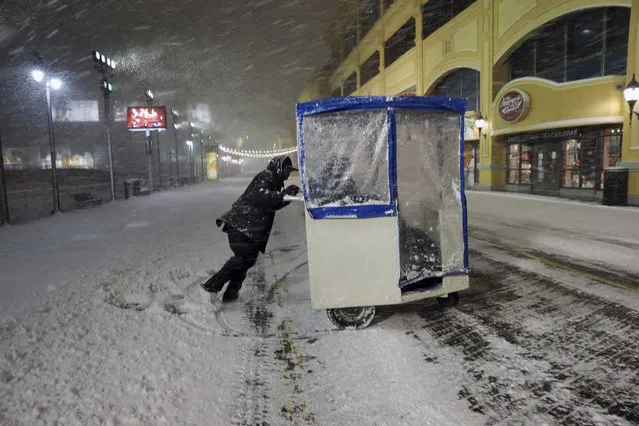 A man maneuvers his Push cart with passengers during a snowstorm early Saturday, January 23, 2016, on the Atlantic City Boardwalk. Most of the state was facing a blizzard warning from Friday evening until Sunday that called for up to 24 inches of snow, with the deepest accumulations in the central part of the state. (Photo by Mel Evans/AP Photo)