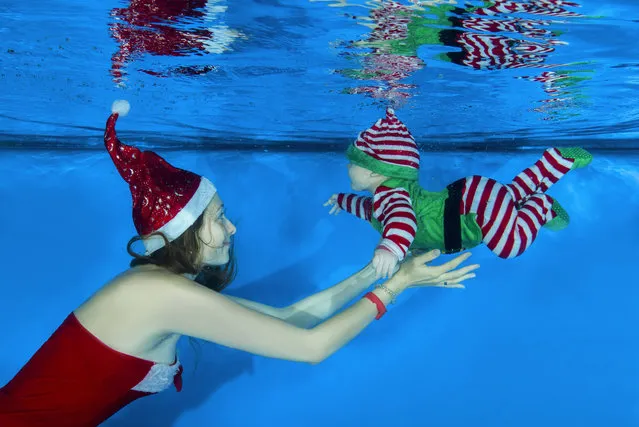 Mom dressed as Santa and a boy dressed as Santa's helper posing under the water in the pool on December 15, 2016 in Odessa, Ukraine. (Photo by Andrey Nekrasov/Barcroft Images)