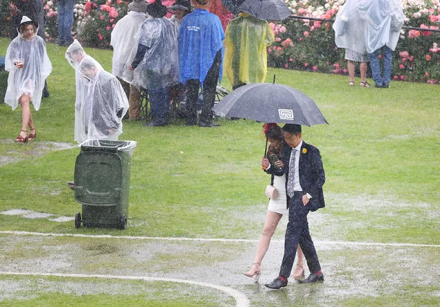 A general view is seen as racegoers walk in puddles as rain tumbles down after race 1 the Ottawa Stakes during Melbourne Cup Day at Flemington Racecourse on November 6, 2018 in Melbourne, Australia. (Photo by Michael Dodge/Getty Images)