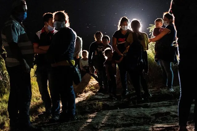 Asylum-seeking migrants' families wait to be escorted by the U.S. Border Patrol agents after crossing the Rio Grande river into the United States from Mexico in Roma, Texas, U.S., July 6, 2021. (Photo by Go Nakamura/Reuters)