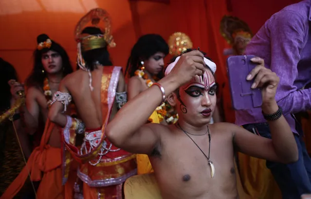 A Hindu man applies makeup as he prepares to participate in a religious procession on Ram Navami festival in New Delhi, India, Saturday, March 28, 2015. (Photo by Altaf Qadri/AP Photo)