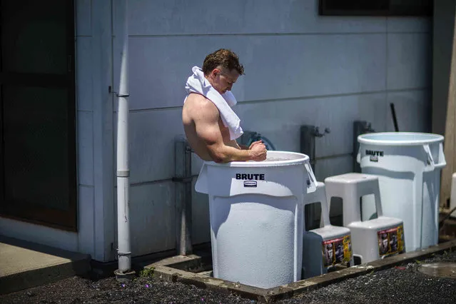 Australia's Henry Hutchison takes an ice bath in a garbage bin following a men's rugby sevens practice at the Tokyo 2020 Olympics, in Tokyo, Friday, July 23, 2021. (Photo by David Goldman/AP Photo)