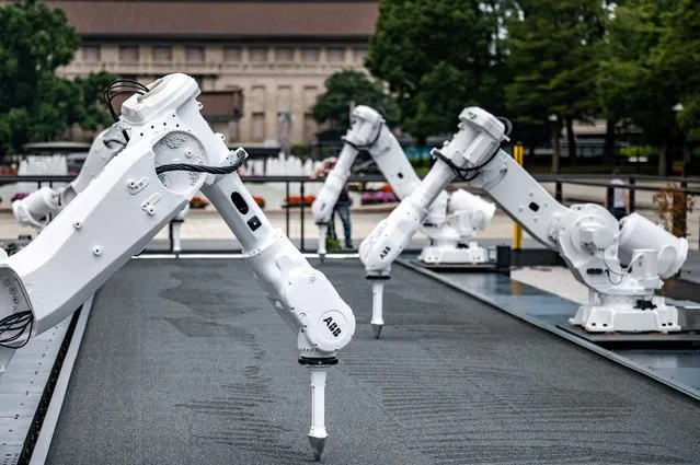 A large-scale outdoor robotic art installation inspired by the Olympic and Paralympic Games “The Constant Gardeners” by Jason Bruges is seen making the patterns referring to the movement of the Olympic flame torch runners, at Ueno park of Tokyo, as part of “Tokyo Tokyo FESTIVAL Special 13” on July 28, 2021. (Photo by Philip Fong/AFP Photo)