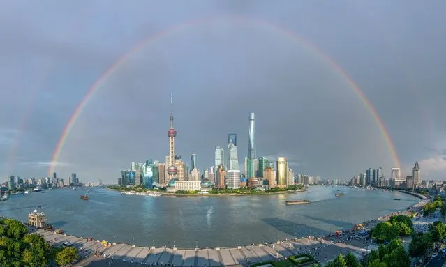 A rainbow appears in the sky above buildings at Lujiazui Financial District after a rainfall on August 17, 2023 in Shanghai, China. (Photo by VCG/VCG via Getty Images)