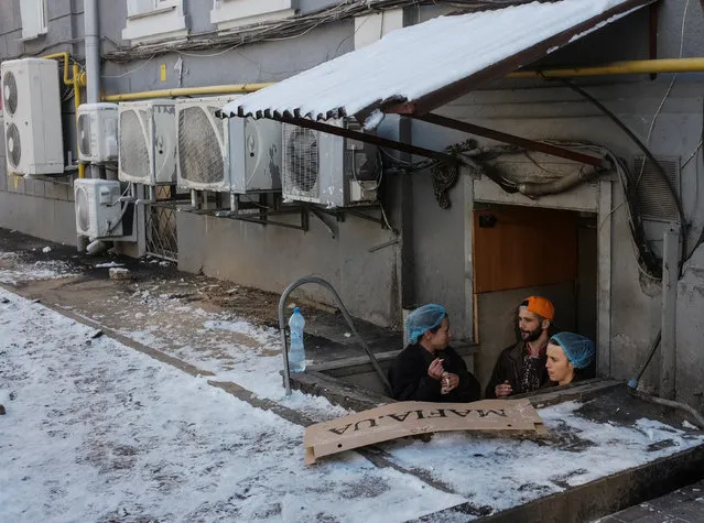 Restaurant employees smoke near a service entrance in central Kiev, Ukraine January 9, 2019. (Photo by Gleb Garanich/Reuters)