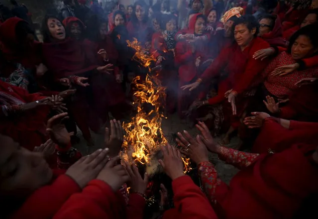 Devotees gather around the fire near the bank of Triveni River to keep them warm after taking a holy bath during the Swasthani Bratakatha festival in Panauti near Kathmandu, Nepal, February 12, 2016. (Photo by Navesh Chitrakar/Reuters)