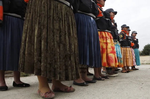 In this December 13, 2013, so-called “traffic cholitas” stand in formation before heading out to the streets to control and direct traffic in El Alto, Bolivia. (Photo by Juan Karita/AP Photo)