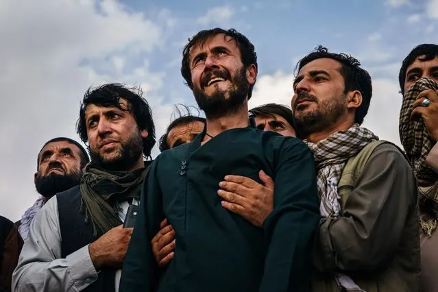 Ramal Ahmadi, center, is supported by family members as he weeps looking up D Jet fighters circle the skies above as the U.S. withdrawal concludes, during a mass funeral for the 10 people the family said were killed in a U.S. drone strike, in Kabul, Afghanistan, Monday, August 30, 2021. (Photo by Marcus Yam/Los Angeles Times/Rex Features/Shutterstock)