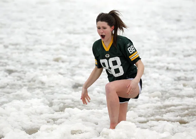 Dana Kenney, Fox Point screams from the cold as she exits the lake after a short dip. The annual Polar Bear Plunge in Milwaukee was held at Bradford Beach on Wednesday, January 1, 2014. (Photo by Mike De Sisti)