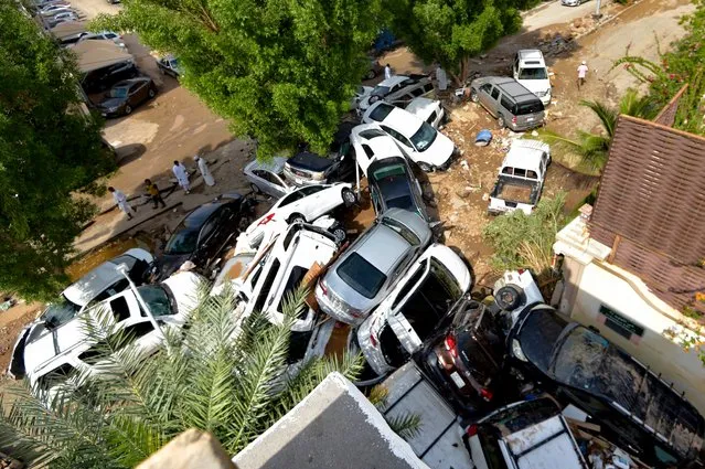 Cars that were washed away by heavy rains are piled up in an alley in the Saudi coastal city of Jeddah on November 25, 2022. At least two people died yesterday as heavy rains hit western Saudi Arabia, including the coastal city of Jeddah, delaying flights and forcing schools to close, officials said. (Photo by Amer Hilabi/AFP Photo)