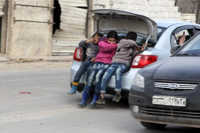 Children ride in the trunk of a car in Kafr Hamra village, northern Aleppo countryside, Syria February 27, 2016. Picture taken February 27, 2016. (Photo by Abdalrhman Ismail/Reuters)