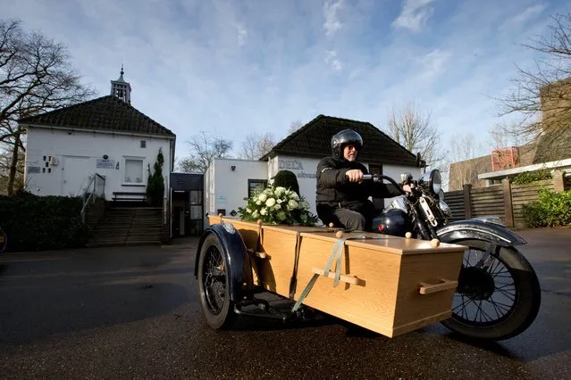The casket of Ad van Antwerpen takes the last ride on a Harley Davidson motorcycle hearse towards the crematory in Bergen op Zoom, south-western Netherlands, Friday January 24, 2014. Van Antwerpen, who died at the age of 69 had a passion for motorcycles but never drove one because of epilepsy, “impossible to drive one when living, but possible on his last journey”, according to his son Vincent. The 1948 WLC Harley Davidson motorcycle was driven by Fred van Essen who operates a special funeral transport service. (Photo by Peter Dejong/AP Photo)