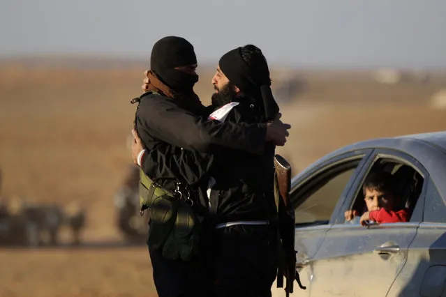 Rebel fighters embrace each other on the outskirts of the Islamic State-controlled northern Syrian town of al-Bab, Syria February 3, 2017. (Photo by Khalil Ashawi/Reuters)