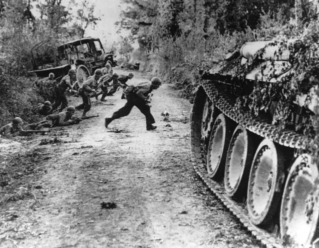 During the Allied invasion of the Normandy region in France, American soldiers race across a dirt road while they are under enemy fire, near St. Lo, in July 1944. The D-Day invasion that helped change the course of World War II was unprecedented in scale and audacity. Veterans and world dignitaries are commemorating the 79th anniversary of the operation. (Photo by Pool via AP Photo)