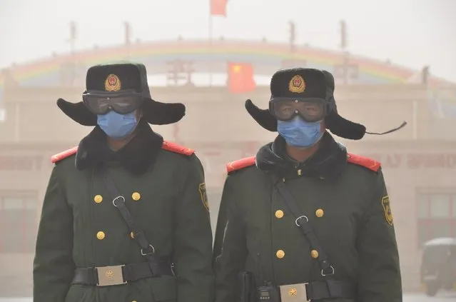 Soldiers of the People's Liberation Army (PLA) stand guard as sand blows in Xilin Gol League, Inner Mongolia Autonomous Region, China, March 28, 2016. (Photo by Reuters/Stringer)