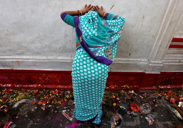 A Hindu devotee touches the wall of a temple as she offers prayers during the Maha Shivaratri festival in Kolkata, India February 24, 2017. (Photo by Rupak De Chowdhuri/Reuters)