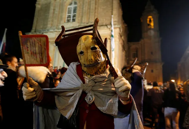 A masked reveller carries a chair as part of his costume during a spontaneous carnival characterised by improvisation, satire and the macabre, in the village of Ghaxaq, Malta, February 27, 2017. (Photo by Darrin Zammit Lupi/Reuters)