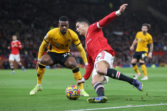 Cristiano Ronaldo of Manchester United is challenged by Nelson Semedo of Wolverhampton Wanderers during the Premier League match between Manchester United and Wolverhampton Wanderers at Old Trafford on January 03, 2022 in Manchester, England. (Photo by Clive Brunskill/Getty Images)